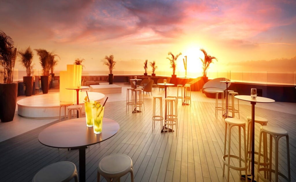 Terras met zonsondergang met tafels en stoelen op Tenerife.