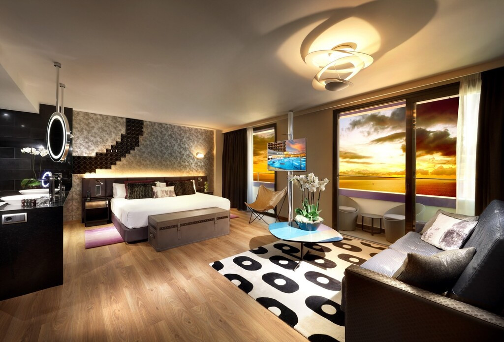 Buitenzwembad van het hotel op Tenerife met ligstoelen en waterstralen.