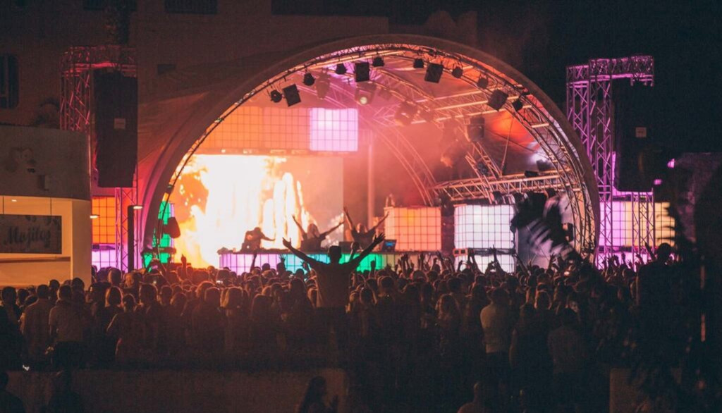 Avondconcert op Tenerife met een menigte voor een verlicht podium.