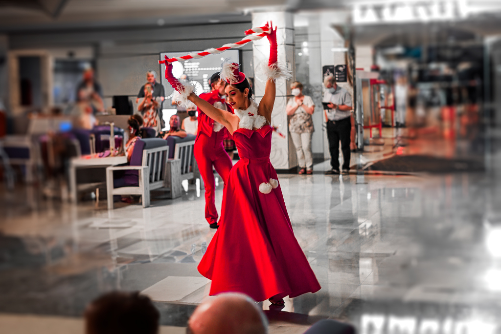 Danser in rode jurk die optreedt op Tenerife, mensen kijken op de achtergrond.