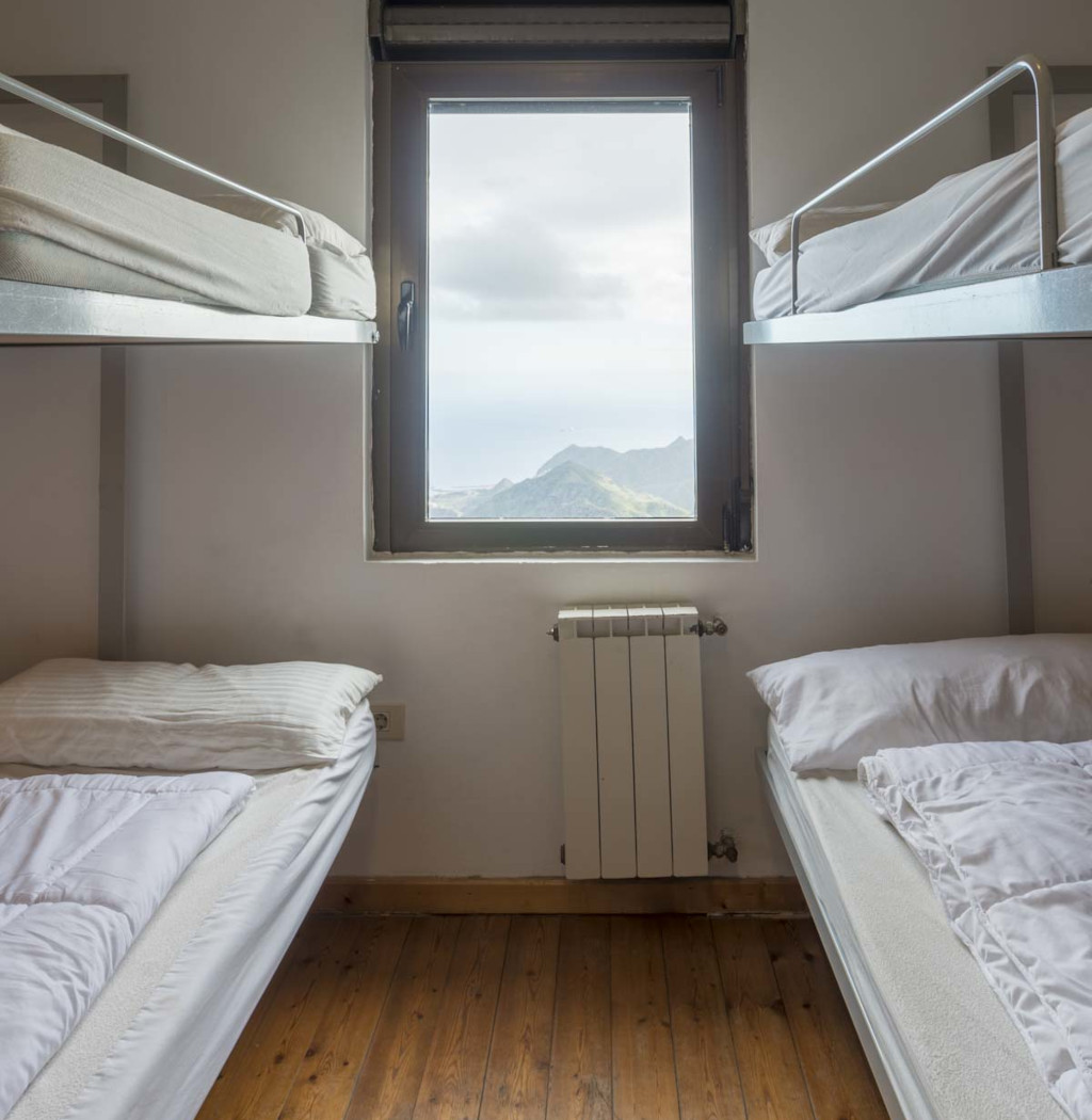 Stapelbedden in een slaapkamer met uitzicht op de bergen van Tenerife door het raam.