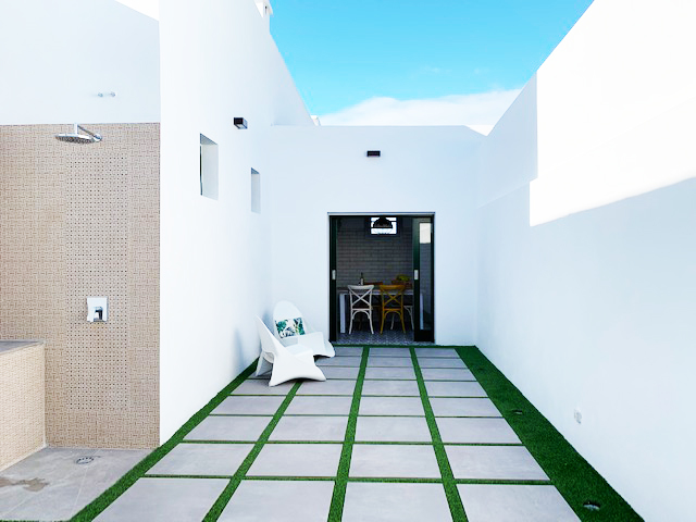 Een modern terras met witte stoelen en een betegeld pad op Tenerife.