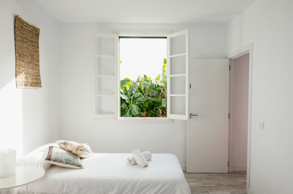 Lichte kamer met eenpersoonsbed en open raam, uitzicht op de buitenkant op Tenerife.