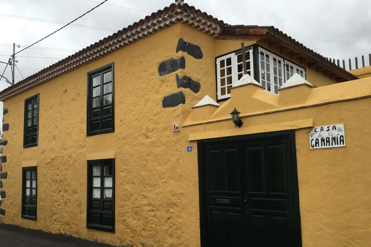 Huis in La Gañanía met gele gevel en zwarte ramen in La Orotava, Tenerife.
