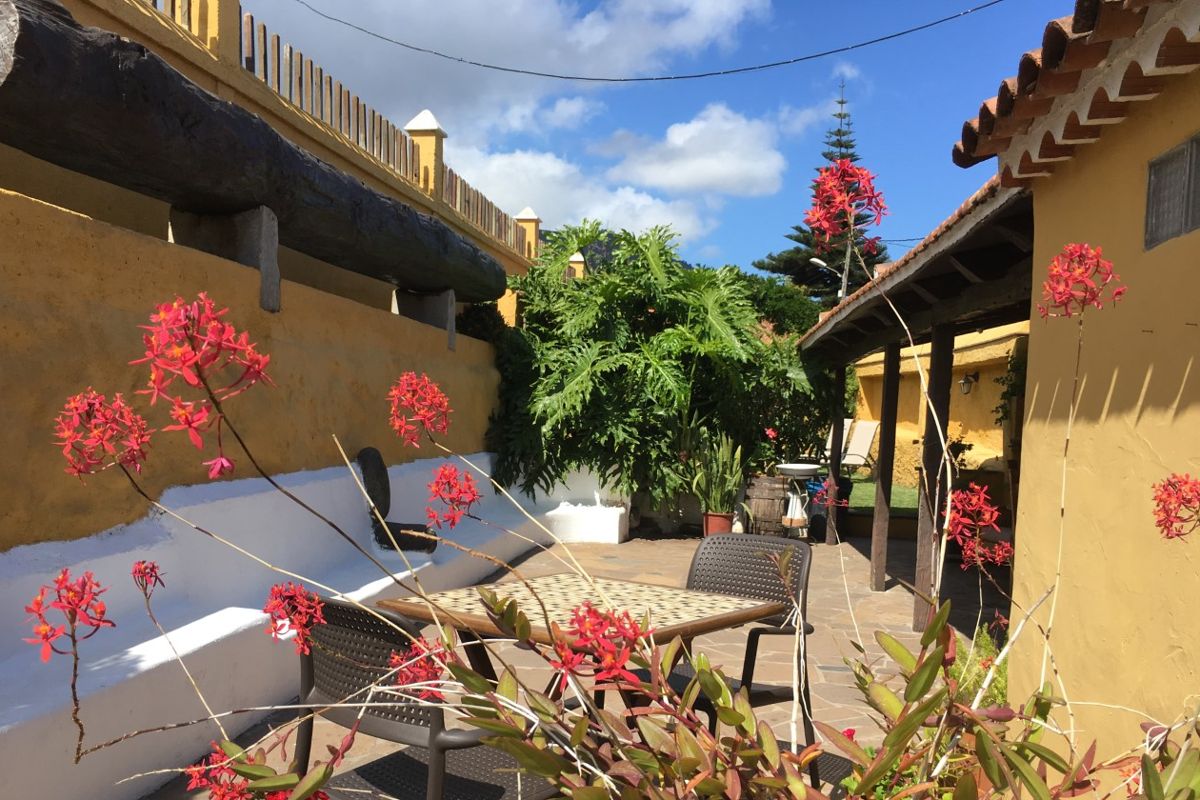 Terras met stoelen en rode bloemen in een huis op Tenerife.