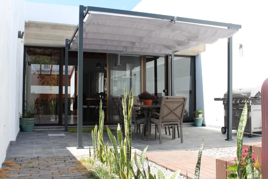 Terras met tafel, stoelen en pergola bij Casa de Tenerife.