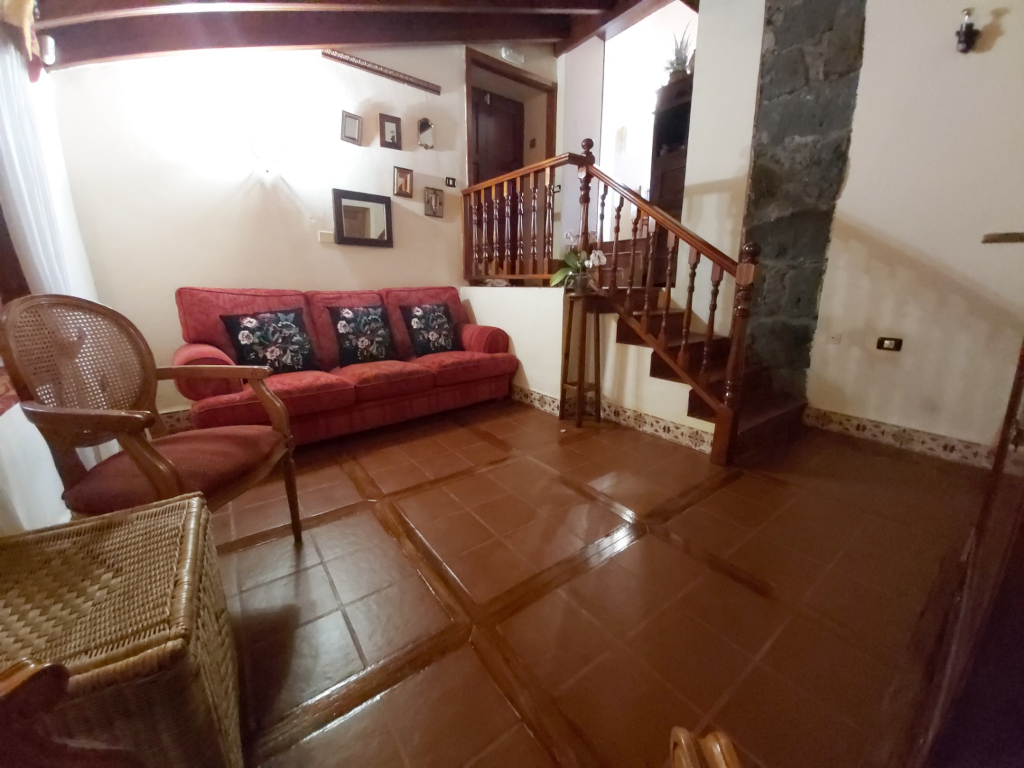 Woonkamer met rode bank en trap in een huis op Tenerife.