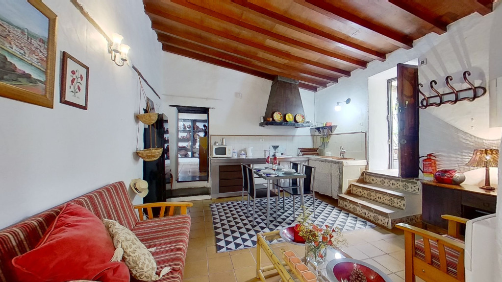 Woonkamer met houten plafond en rustieke keuken in woningen op Tenerife.