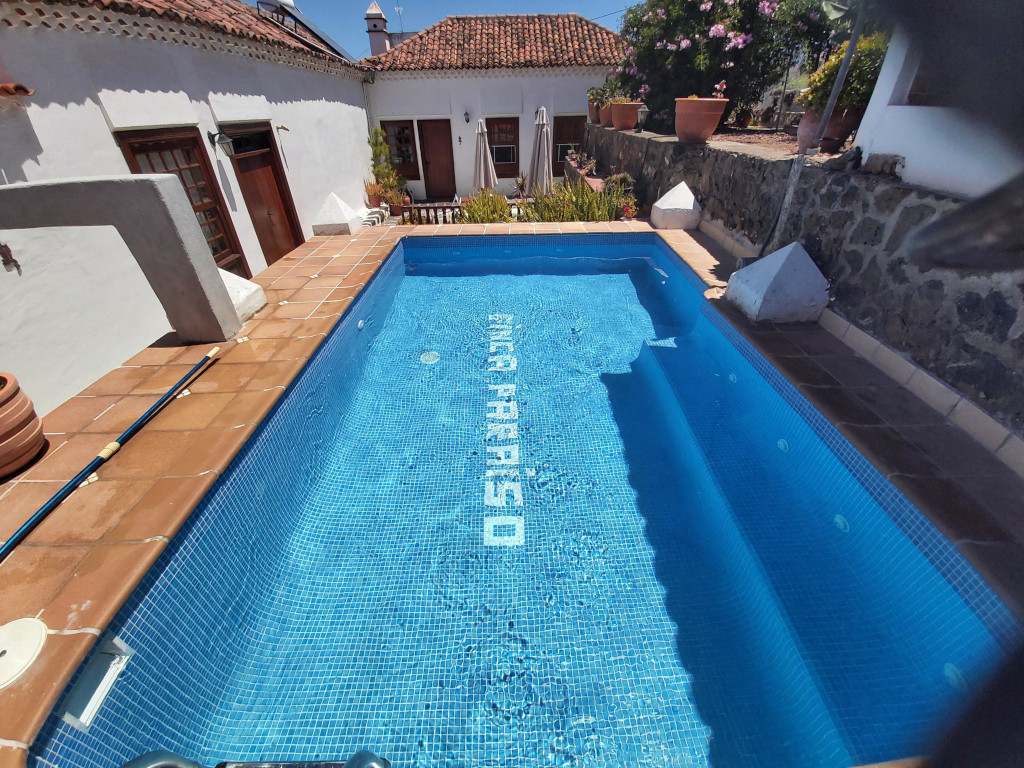 Zwembad in een landelijk huis met tekst FINCA PARAÍSO op de grond, Tenerife.