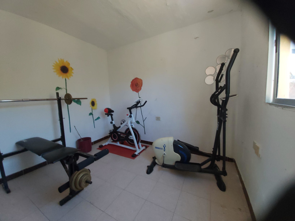 Sportschool op Tenerife met hometrainer en gewichten.