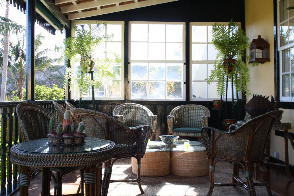 Terras met rotanmeubels, planten en glazen tafel op Tenerife.