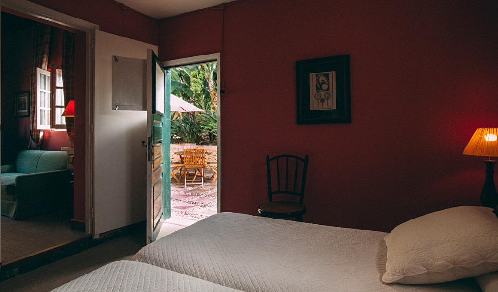Slaapkamer met tweepersoonsbed en toegang tot een terras met tuinmeubilair op Tenerife.