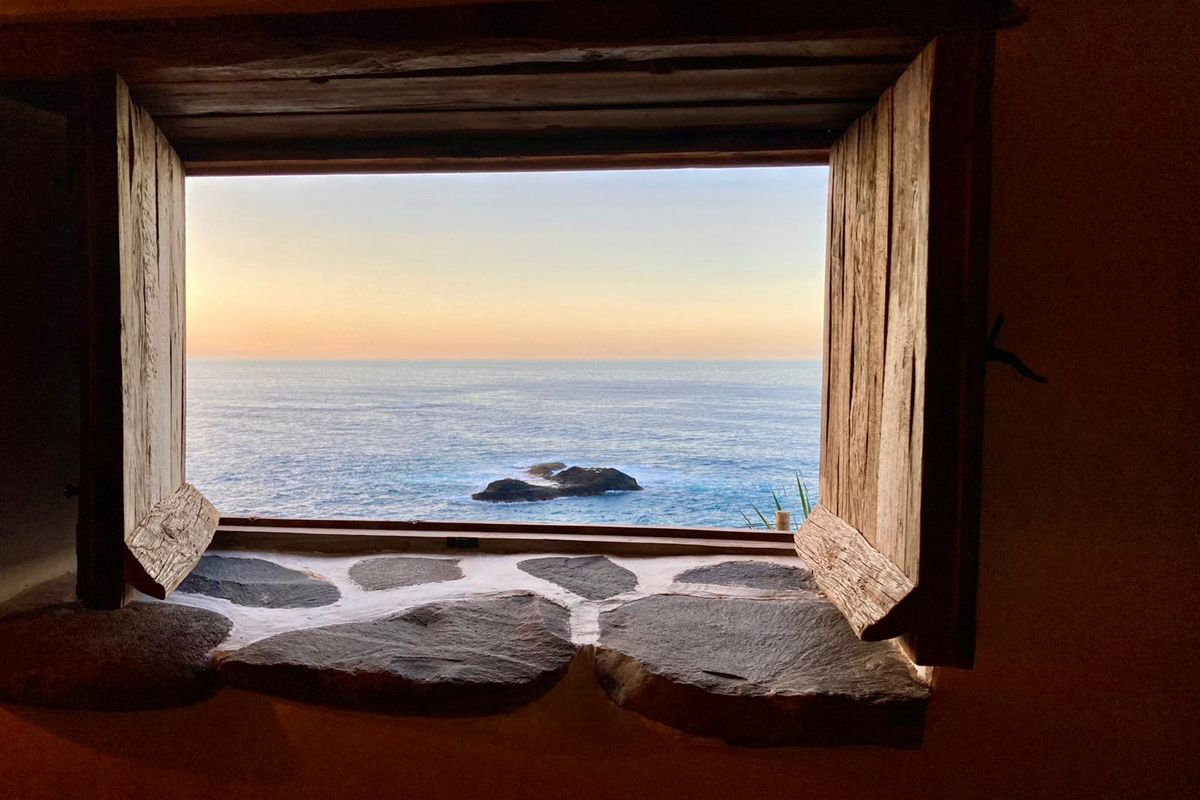 Zeezicht vanuit een rustiek raam in Garachico, Tenerife.