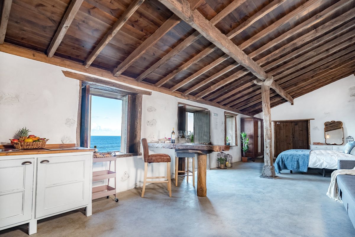 Rustieke kamer met houten plafond, zeezicht en bed op Tenerife.
