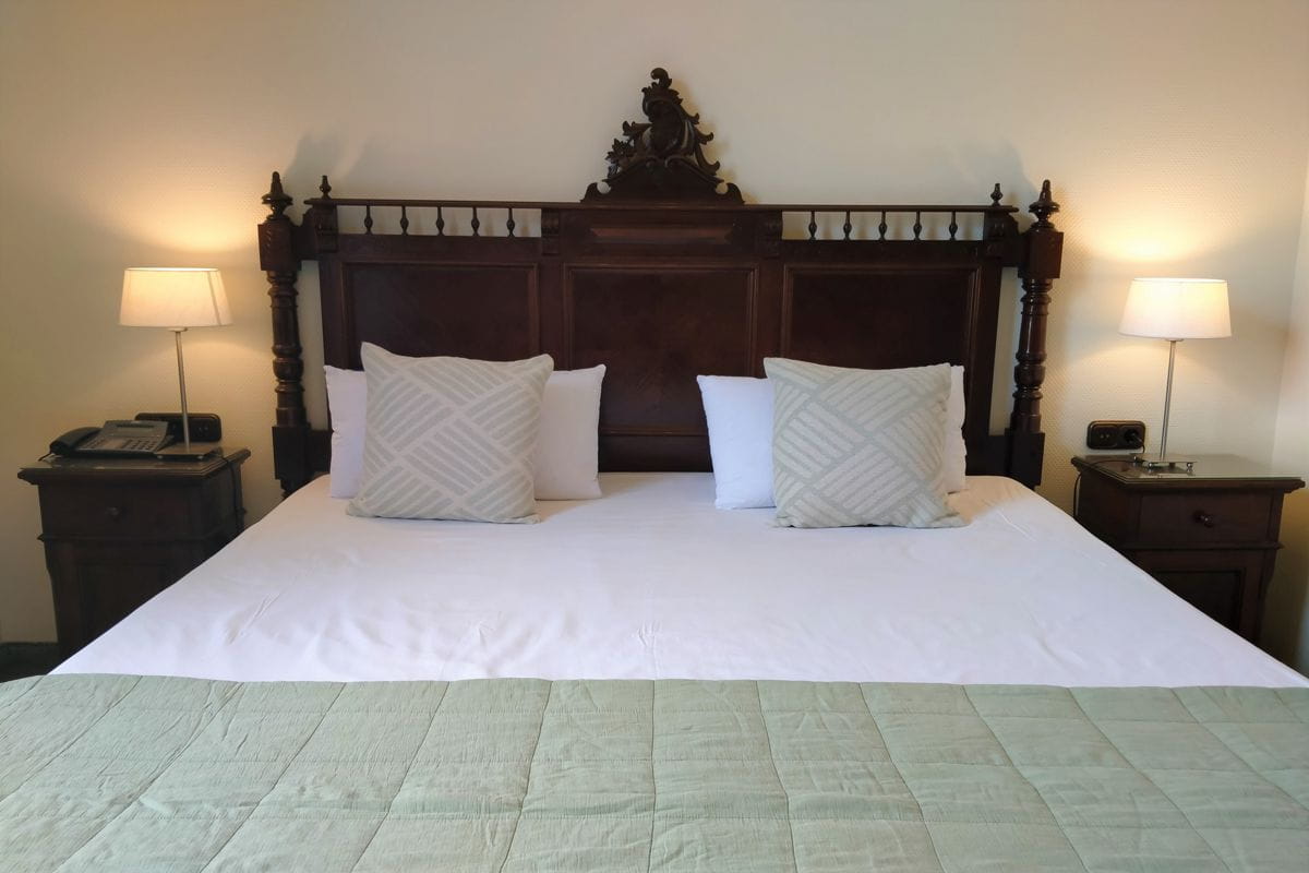 Tweepersoonsbed met houten hoofdeinde in een hotel op Tenerife.