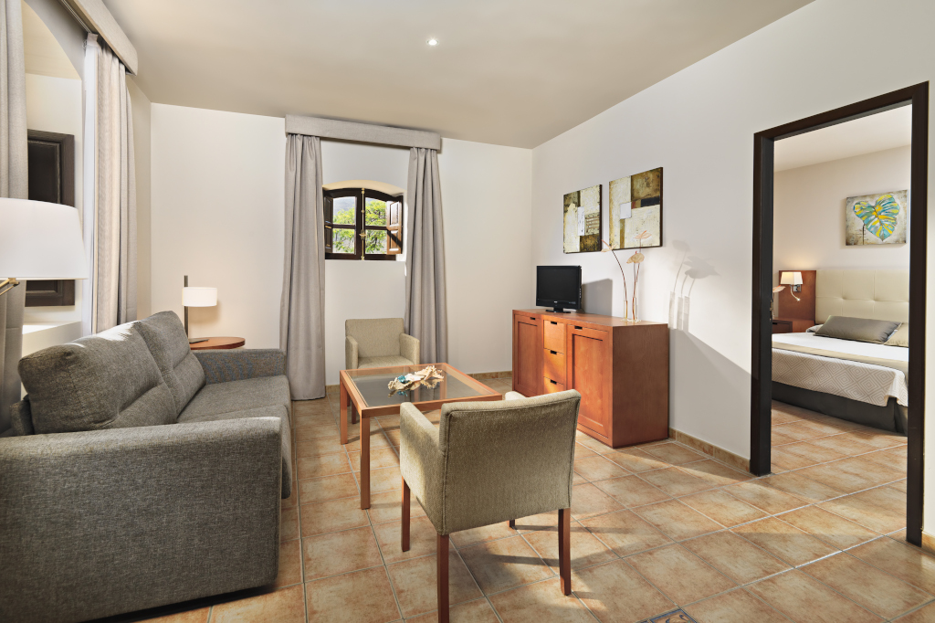 Woonkamer in een appartement op Tenerife met bank, tafel en televisie.