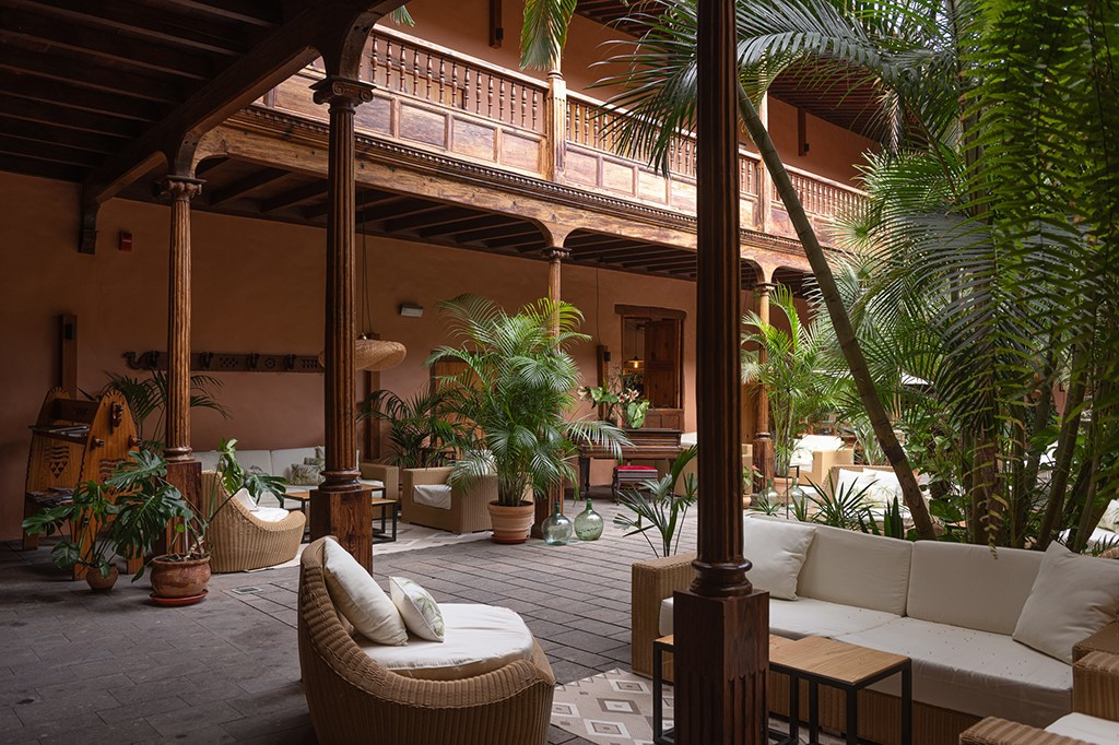 Binnenplaats met rotanmeubels en planten in een hotel op Tenerife.
