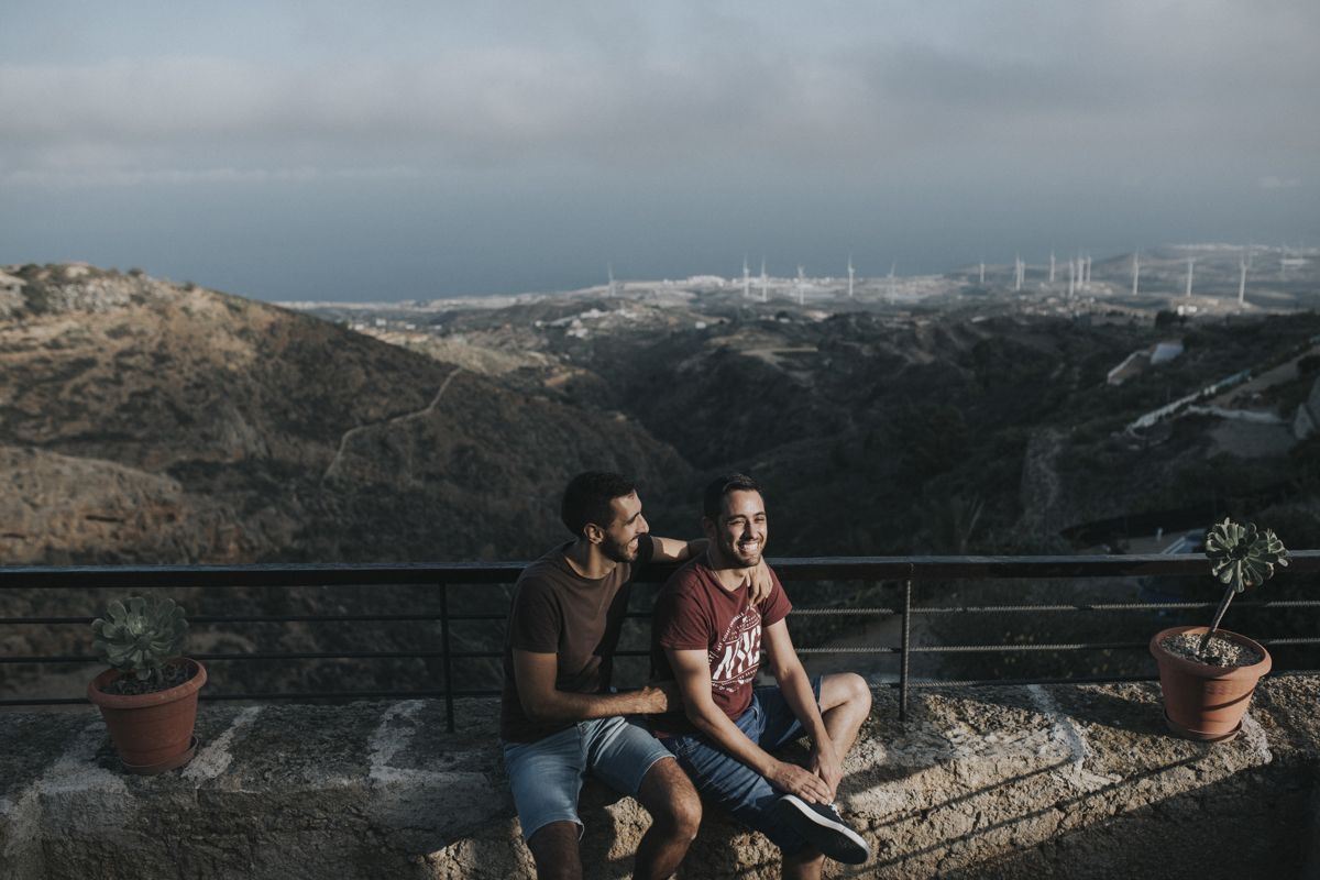 Twee mensen zitten op een uitkijkpunt met panoramisch uitzicht op Tenerife.