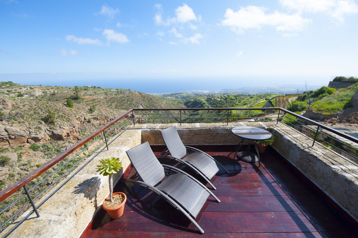 Terras met ligstoelen en uitzicht op de zee en de bergen op Tenerife.