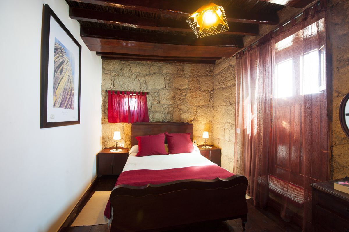 Rustieke kamer met tweepersoonsbed en stenen muren op Tenerife.