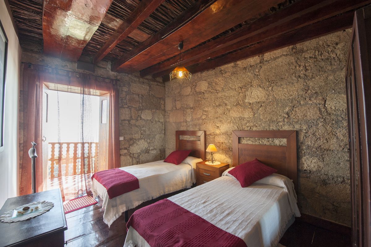 Kamer met twee eenpersoonsbedden en een stenen muur op Tenerife.