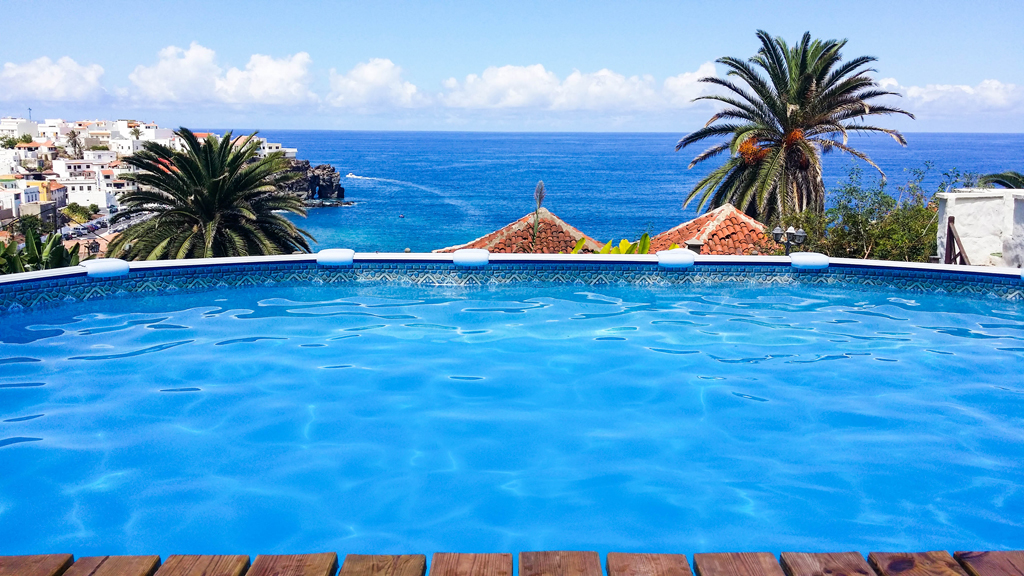 Zwembad met uitzicht op zee en palmbomen op Tenerife.