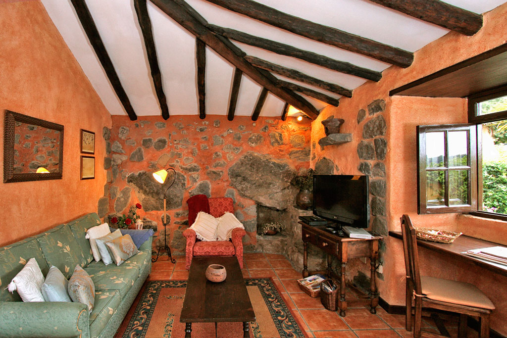 Rustieke woonkamer met bank, stoel, tv en raam op Tenerife.