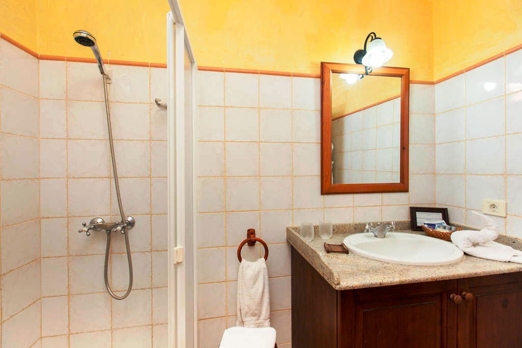 Badkamer met douche, wastafel en spiegel in Los Cristianos, Tenerife.