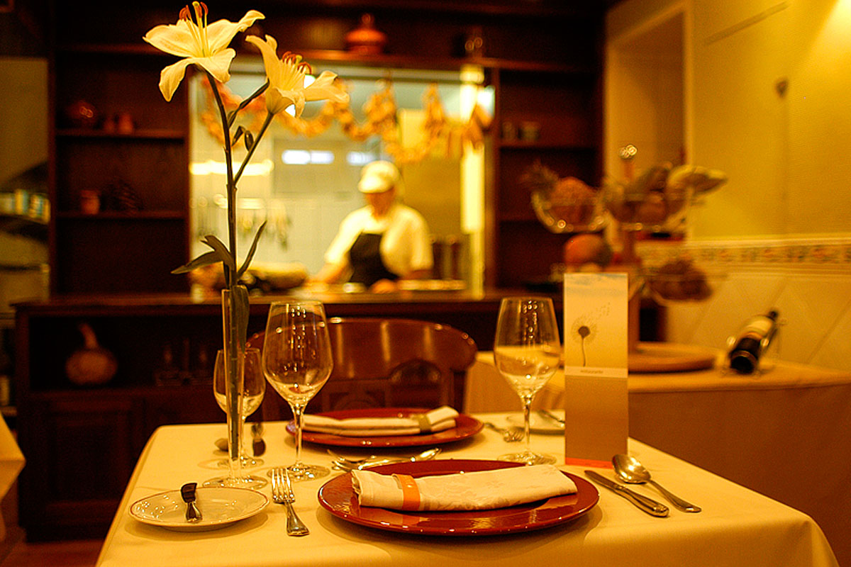 Tafel met glazen, borden en bloemen in restaurant met chef op Tenerife.