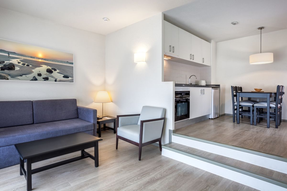 Woonkamer met bank, salontafel, een keuken en eettafel in Tenerife.