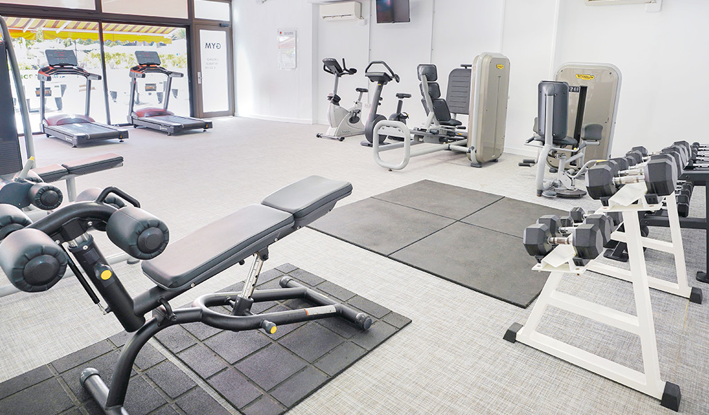 Fitnesscentrum met fitnessapparatuur op Tenerife, waaronder vrije gewichten en cardio-apparaten.