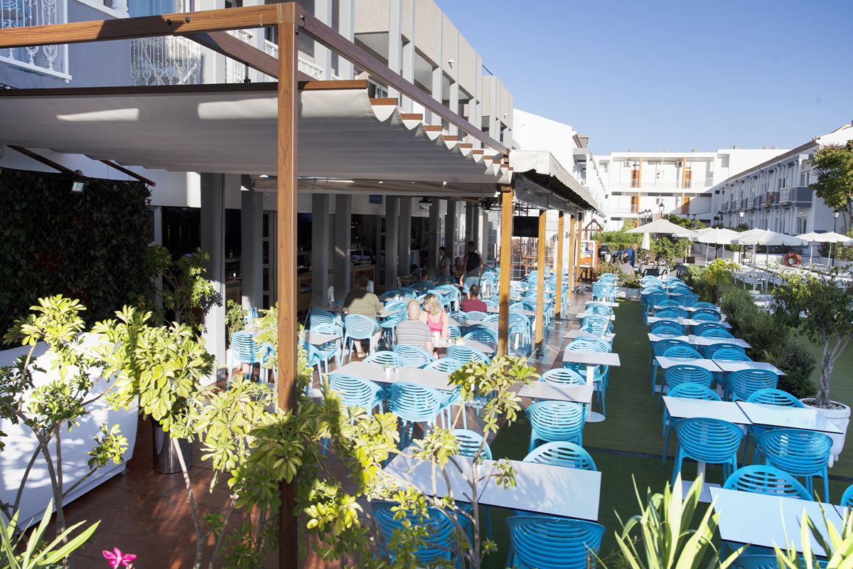 Terras met blauwe tafels en stoelen in een restaurant op Tenerife.