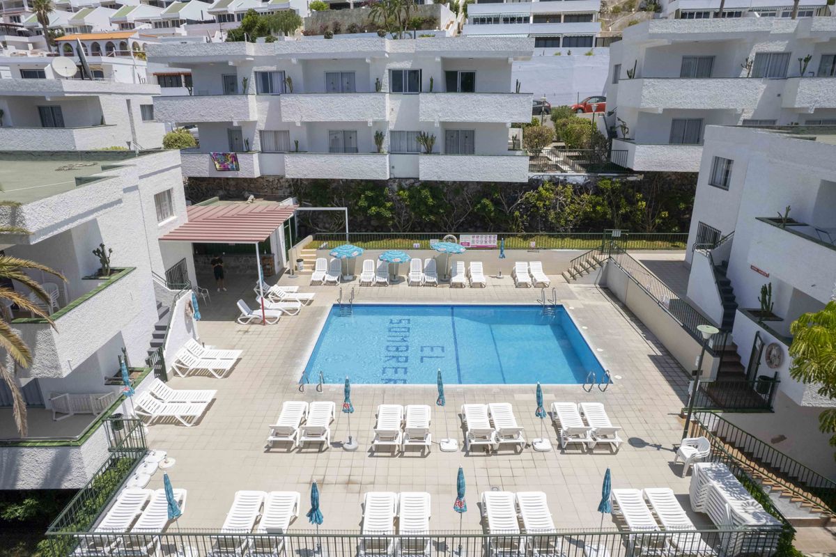 Zwembad van het El Sombrero-complex met ligstoelen en tafels, Tenerife.