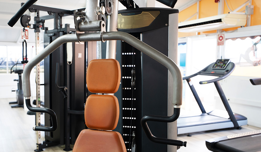 Fitnessapparaat in de gymzaal van Tenerife met loopband op de achtergrond.