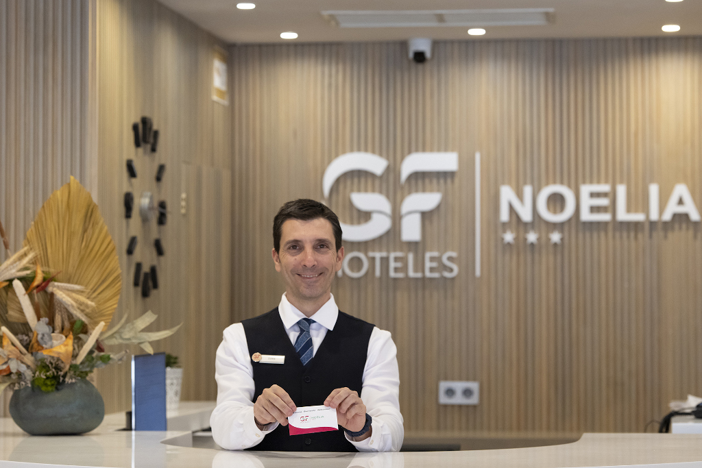 Receptioniste bij GF Hoteles Noelia op Tenerife met een witte kaart.