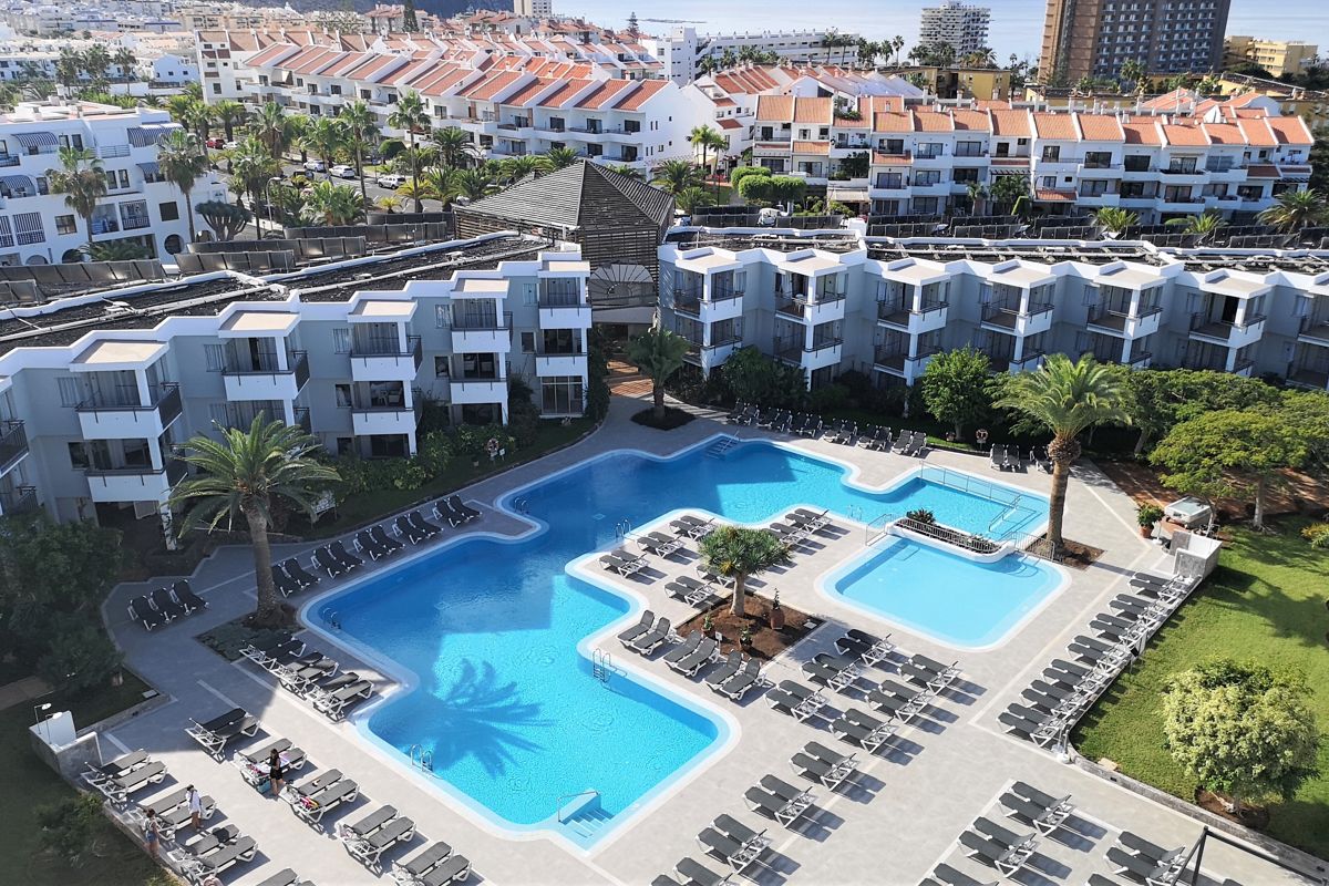 Zwembad van een hotel omringd door hangmatten en gebouwen op Tenerife.