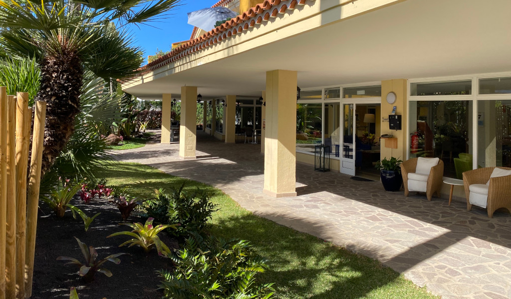 Ingang van een gebouw omringd door palmbomen en een tuin in Puerto de la Cruz, Tenerife.