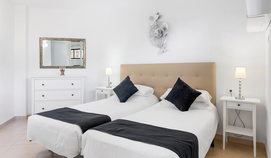 Twee eenpersoonsbedden met hoofdeinde en nachtkastjes in de kamer op Tenerife.