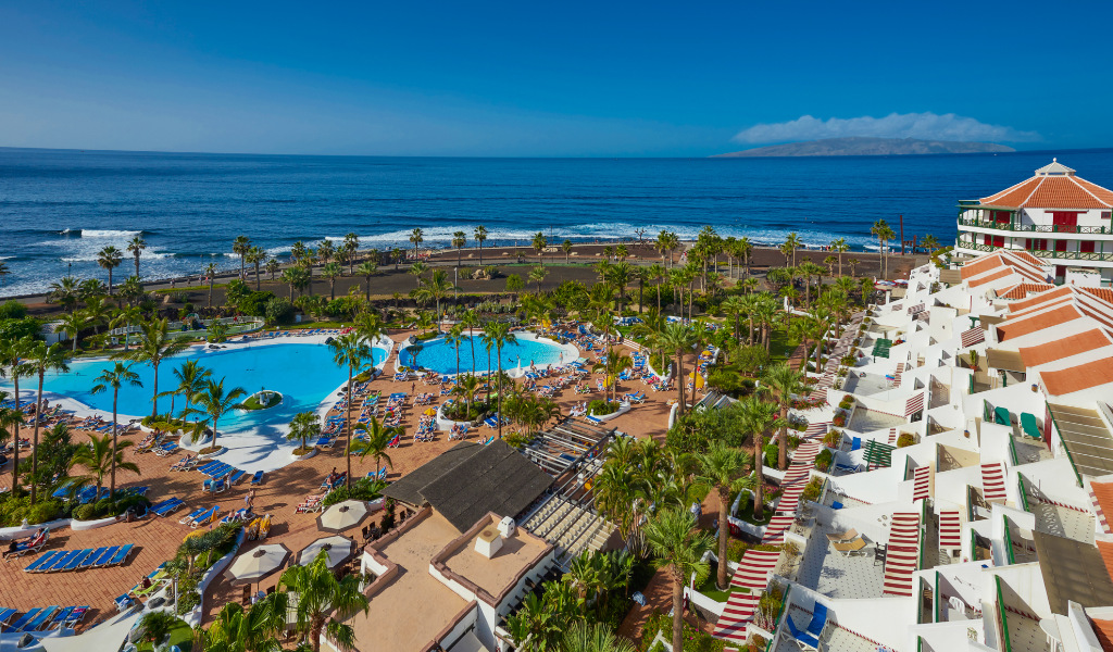 Hotelcomplex op Tenerife met zwembaden aan het strand en ontspanningsruimtes.