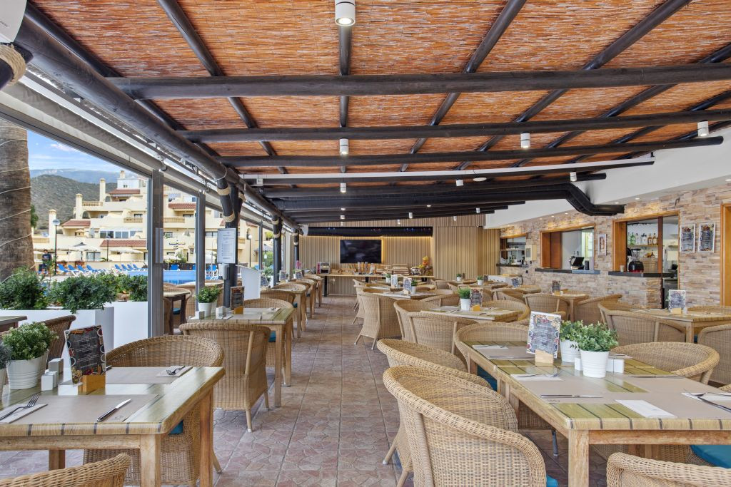 Restaurantterras met rotantafels en stoelen voor het zwembad op Tenerife.