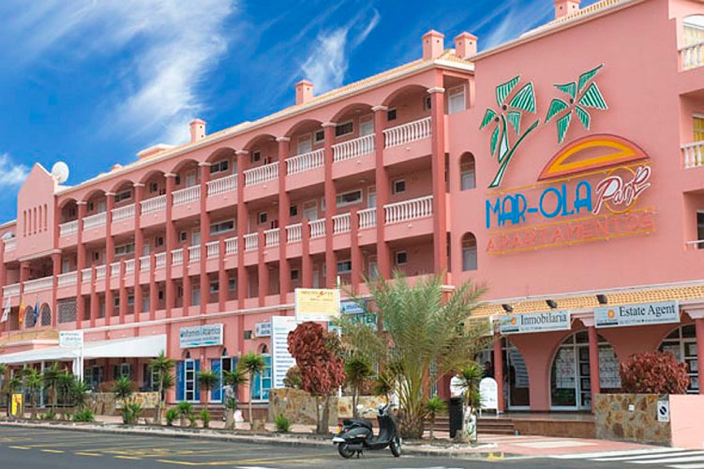 Mar-Ola Park Apartments op Tenerife met een roze gevel en palmbomen.