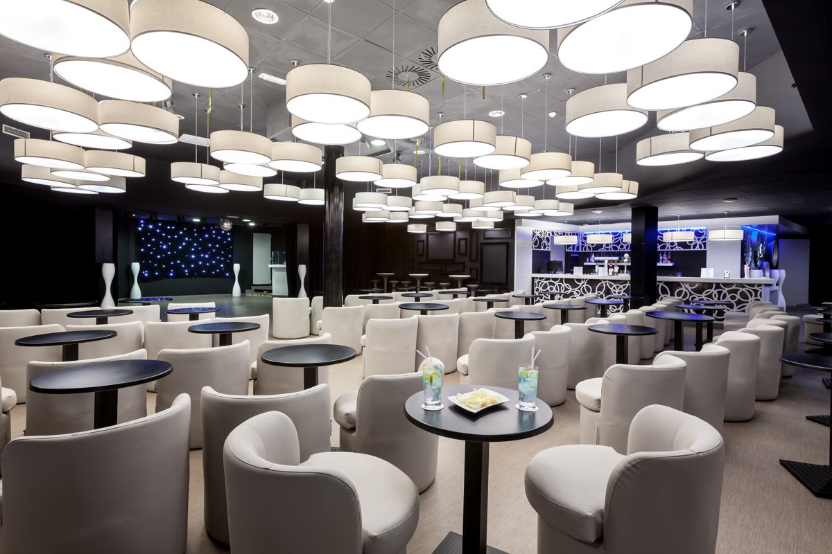 Moderne bar met witte tafels en stoelen in een hotel op Tenerife.