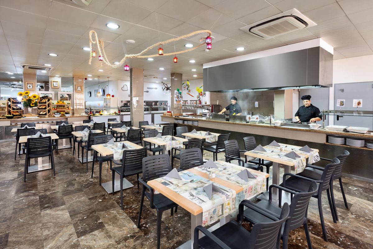 Restaurant met voorbereide tafels en koks die koken op Tenerife.