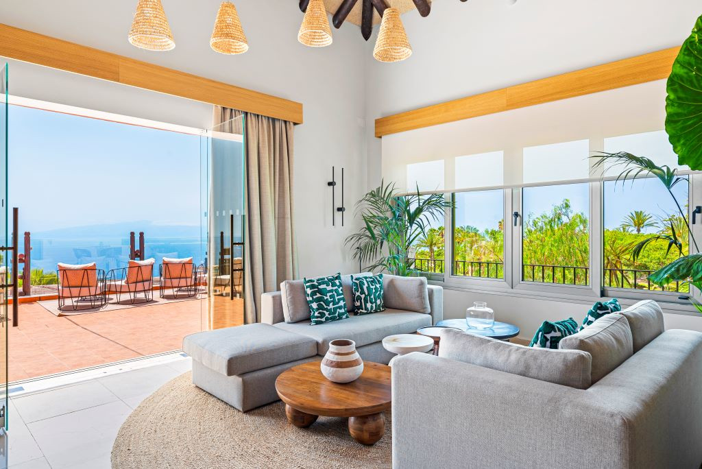 Woonkamer met bank en uitzicht op zee op Tenerife vanaf een open terras.