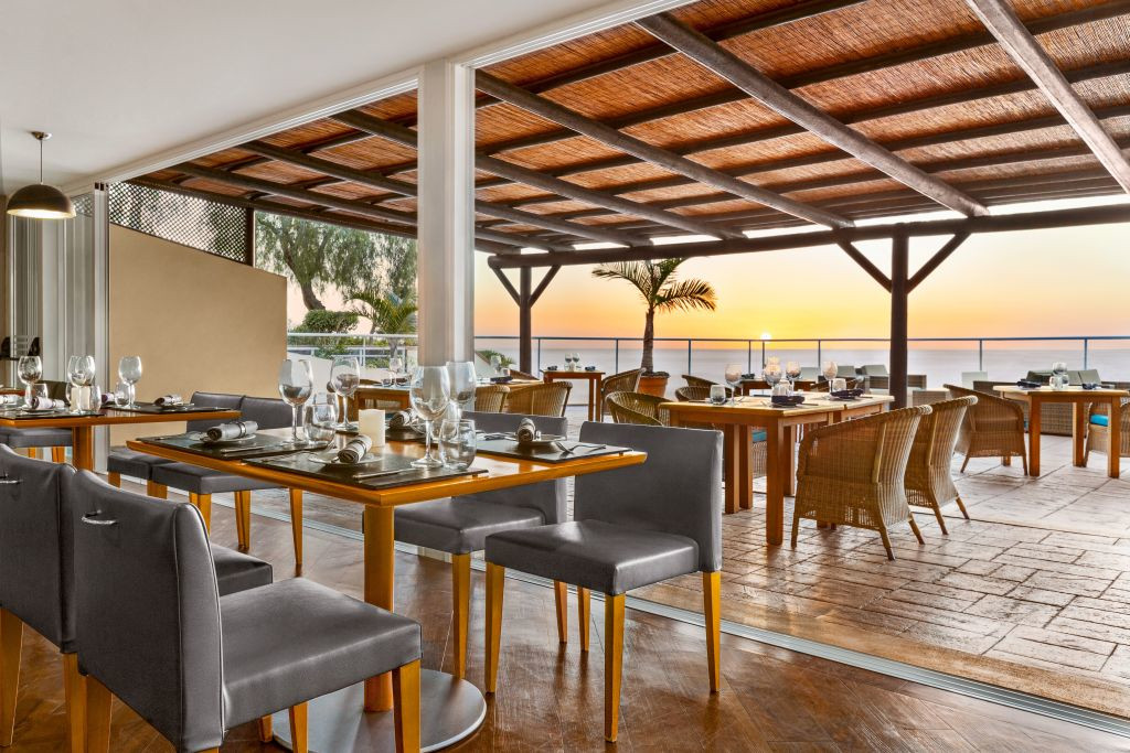 Openluchtrestaurant bij zonsondergang op Tenerife met bediende tafels.