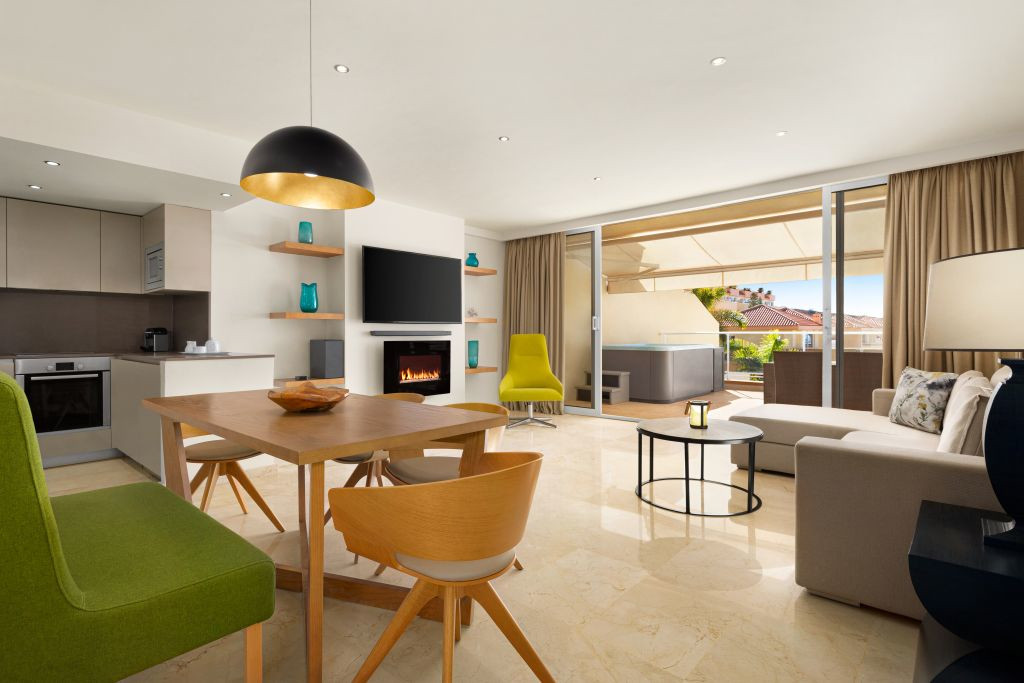 Moderne woonkamer met geïntegreerde keuken en toegang tot het terras op Tenerife.