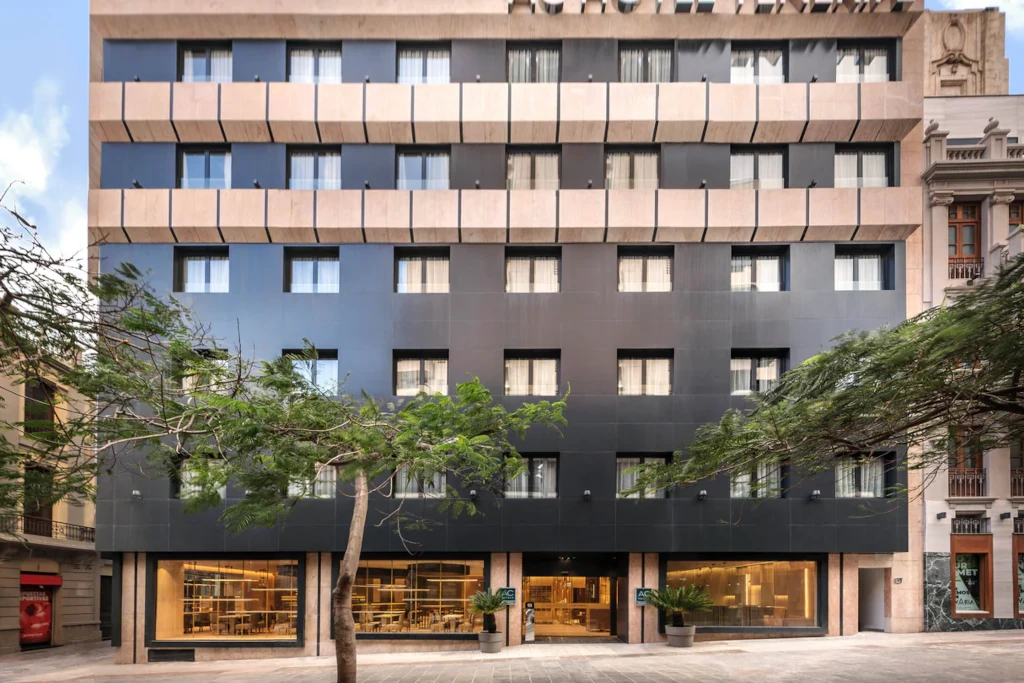 Gevel van een modern hotel in Santa Cruz de Tenerife, met bomen voor het gebouw.