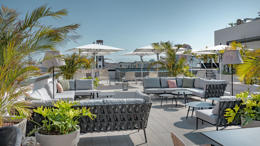 Terras met banken, parasols en planten in een hotel in Santa Cruz de Tenerife.