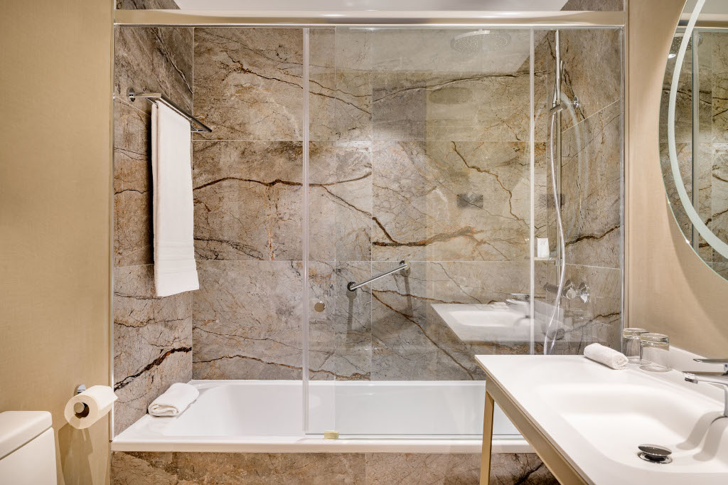 Badkamer met marmeren douche en grote spiegel in een hotel op Tenerife.