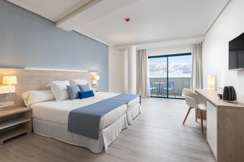 Moderne kamer met tweepersoonsbed en balkon met zeezicht op Tenerife.